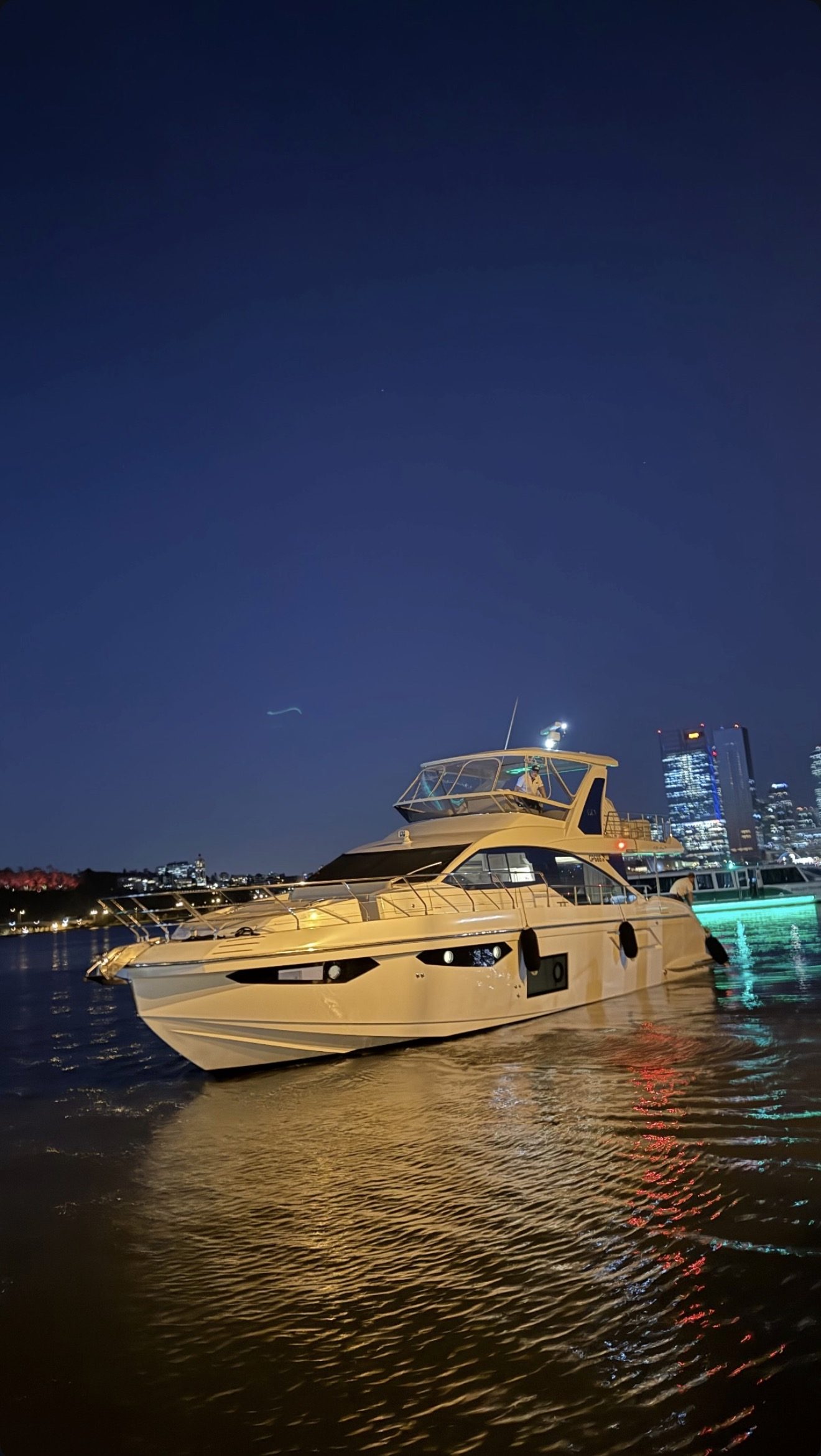 Luxury yacht lit against the Perth skyline at night